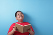 © airdone - Fat Asian boy looking up thinking expression while reading a book
