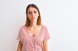 © Krakenimages.com - Beautiful redhead woman wearing casual striped red t-shirt over isolated background Relaxed with serious expression on face. Simple and natural looking at the camera.