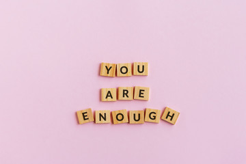 Wall Mural - Inspirational quotes - You are enough text wood blocks. Pink background.