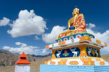 The Old Giant Statue Of Meditating Lord Buddha Sitting Cross Legged On A Mound Above The Village Overlooking Great Himalayan Range. Langza, Fossil Village Spiti Valley, Himachal Pradesh India