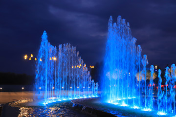 Beautiful pool in the landscape park with a fountain at night against the backdrop of picturesque clouds, big city. Dnipro, Dnipropetrovsk, Ukraine