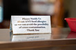 Food allergy cross contamination warning placard notice sitting on stable at restaurant