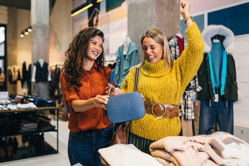 Wall Mural - Female seller helps buyer to choose between diferent clothes.