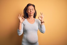 Middle Age Pregnant Woman Expecting Baby At Aged Pregnancy Relax And Smiling With Eyes Closed Doing Meditation Gesture With Fingers. Yoga Concept.