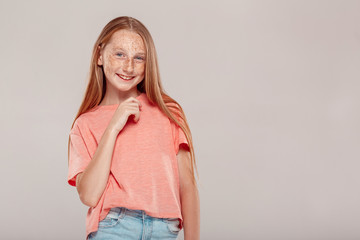 Wall Mural - Inclusive Beauty. Girl with freckles standing isolated on grey posing smiling playful