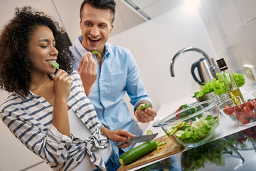 Young adult man and african american woman cooking healthy food together