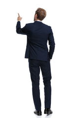 Wall Mural - young businessman in navy blue suit pointing finger up