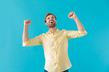 Wall Mural - Happy casual man celebrating with both fists clenched