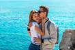 © Serhii - Happy young couple hugging and kissing on blue sea background. Portrait of romantic loving couple on rocky shore.