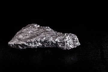 Wall Mural - big big silver nugget on black background. Raw silver stone, silver nugget native to Liberia, isolated on black background. Mineral extraction.