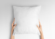 © PIXPINE - White blank square pillow mockup, woman holding with two hands on isolated background