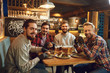 © Studio Romantic - Group of male friends drink beer at a party in a bar.