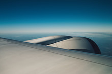Wing Of An Airplane Flying Above The Sky With Clouds And City Land