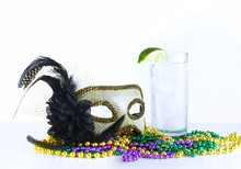 Alcoholic Beverage And Pourple, Green And Gold Mardi Gras Beads With Mask On A Marble Table For A Festive February Holoiday Image. The Drink Is A Gin Fixx Garnished With A Lime.