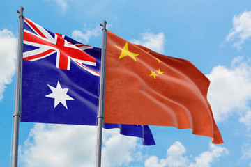 Wall Mural - China and Australia flags waving in the wind against white cloudy blue sky together. Diplomacy concept, international relations.