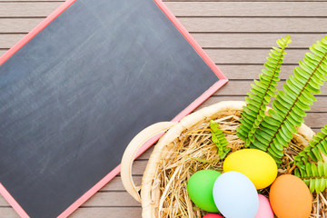 Easter eggs in basket and blackboard