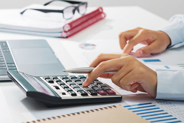 Fototapete - businesswoman working on desk using calculator analyzing finance accounting in office