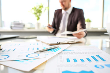 Silver pen lie at important paper on table in office closeup with businessman in background. Paperwork job trade balance bank credit loan money invest payment irs commerce partnership concept