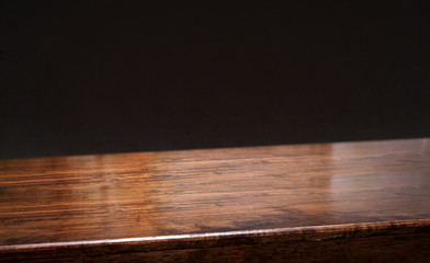 Poster - black background.Empty diagonal brown wooden table with blur black concrete wall backdrop,banner mockup template for display of product