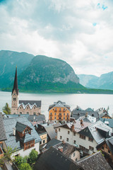 Wall Mural - hallstatt church with bell tower lake with alpine mountains on background