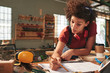 © DragonImages - Young attractive female carpenter thoroughly checking measurements on blueprint before working with wood