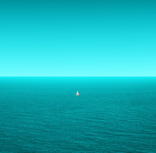 A Lonely Sailboat Sails Through The Vast Ocean - Calm Turquoise Sea And Sky