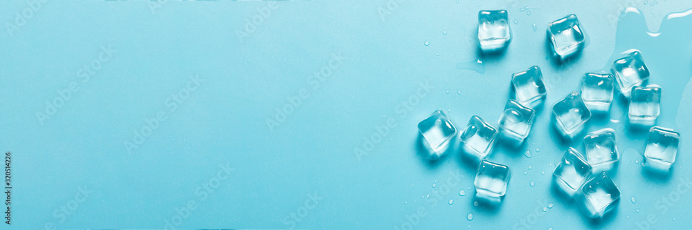 Ice cubes with water on a blue background. Ice concept for drinks. Banner. Flat lay, top view - obrazy, fototapety, plakaty 