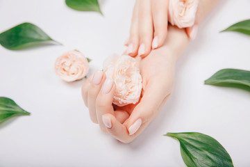 Wall Mural - Concept beauty. Beautiful stylish trendy female pink manicure with flower on background, top view