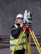 © Philipp Berezhnoy - Pretty smiling young mining surveyor woman stands by geodetic total station in the tunnell of metro under construction