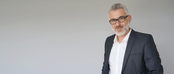 Portrait of businessman standing on grey background - template