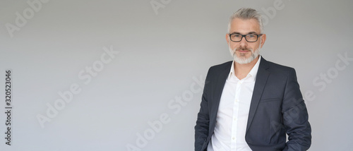 Fotografía Portrait of businessman standing on grey background - template
