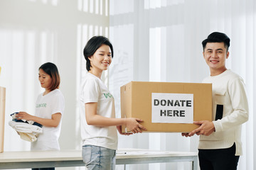 Sticker - Positive Vietnamese volunteers carrying box with donated clothes