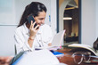 © BullRun - Cheerful confident entrepreneur talking on phone in light modern office