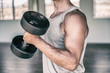 © Maridav - Gym fitness workout fit man training biceps muscles with free weights lifting dumbbells for arm workout.
