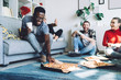 © BullRun - Multiracial friends eating pizza at home
