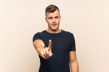 Wall Mural - Young handsome blonde man over isolated background showing and lifting a finger