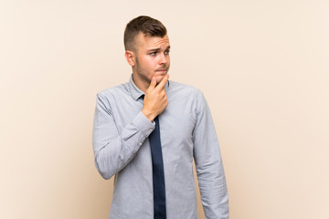 Young blonde businessman over isolated background thinking an idea