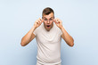 © luismolinero - Young handsome blonde man over isolated blue background with glasses