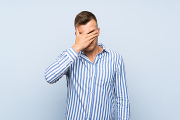 Wall Mural - Young handsome blonde man over isolated blue background covering eyes by hands. Do not want to see something