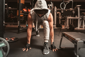 A bearded sporty man in the gym is doing yoga exercises, practicing standing in the plank pose, doing push up or push up exercises.