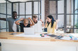 © BullRun - Group of enthusiastic multiethnic coworkers using laptop at office