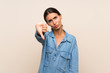 © luismolinero - Young woman over isolated background showing thumb down with negative expression