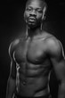 © monchak - black and white portrait of a handsome black man with naked sports torso looking in the camera on dark background