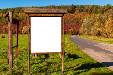 Poster - Blank white advertisement/annoucement board on the meadow. Sunny autumn day