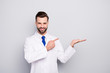 © deagreez - Portrait of his he nice attractive cheerful cheery confident doc holding on palm showing copy space new solution alternative isolated on light white gray pastel color background