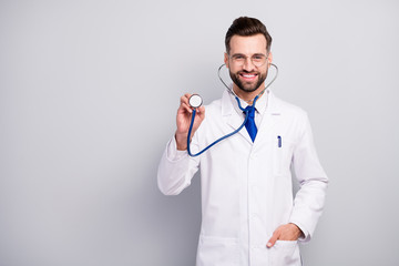 Canvas Print - Portrait of nice attractive careful cheerful cheery bearded doc listening your breathing heart beat medicare first aid help assistance isolated on light white gray pastel color background