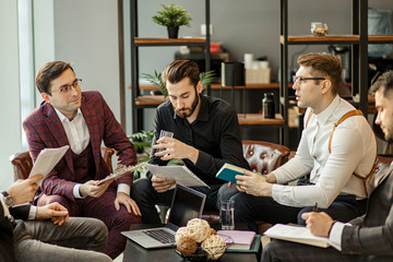 Wall Mural - serious business people hold meeting in office for discussing and speaking about business projects, ideas and strategies for future. successful confident men in elegant suits indoors