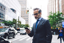 Middle Aged Businessman Looking Into Smartphone Near Road