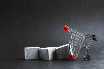 Shopping cart and box on dark background, business, shopping concept. Selective focus