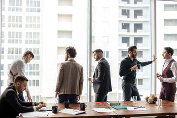 business people wearing formal wear gathered in office for holding business conference with partners, successful young guys together in modern boardroom